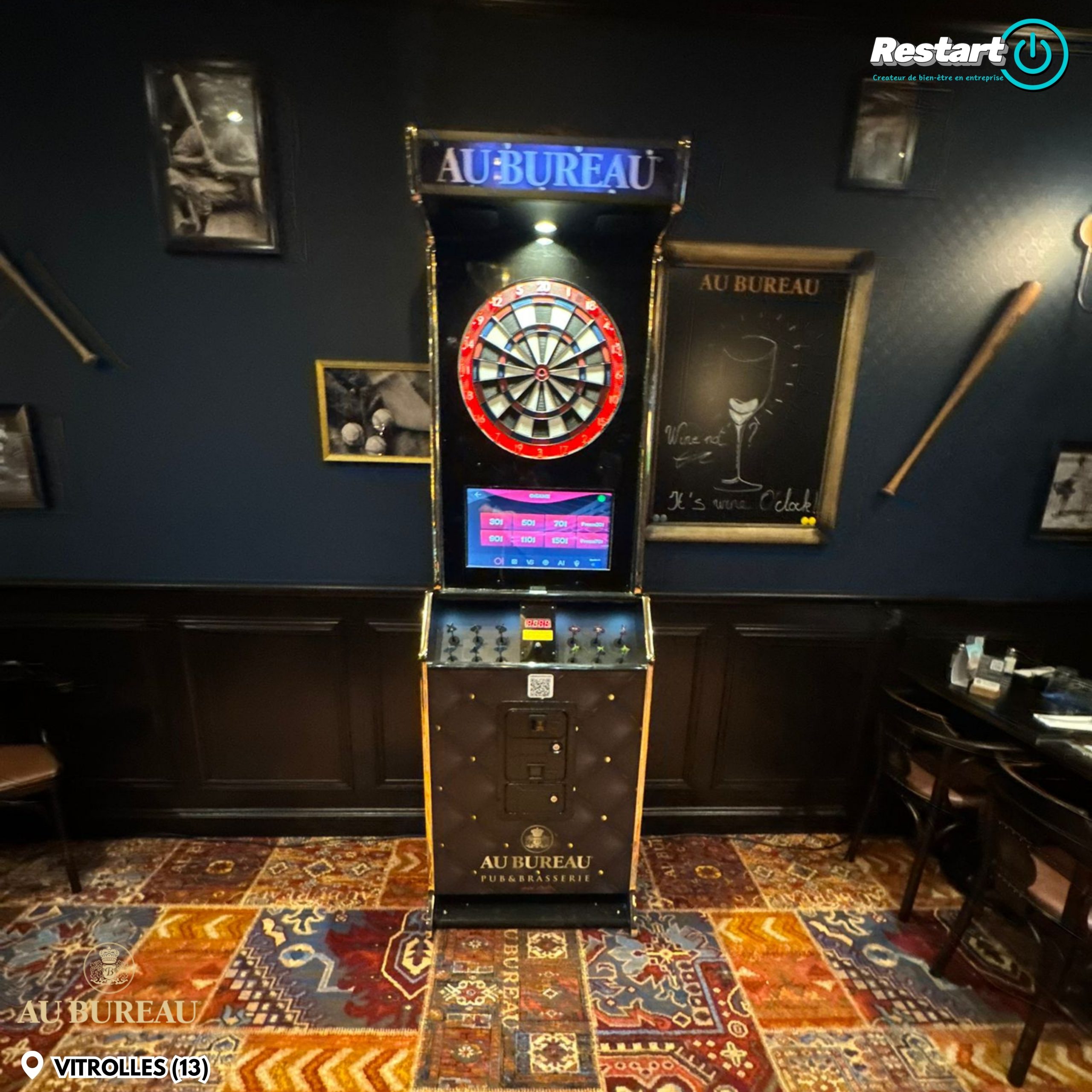 Vue rapprochée de la fléchette interactive noire et dorée installée au restaurant Au Bureau de Vitrolles
