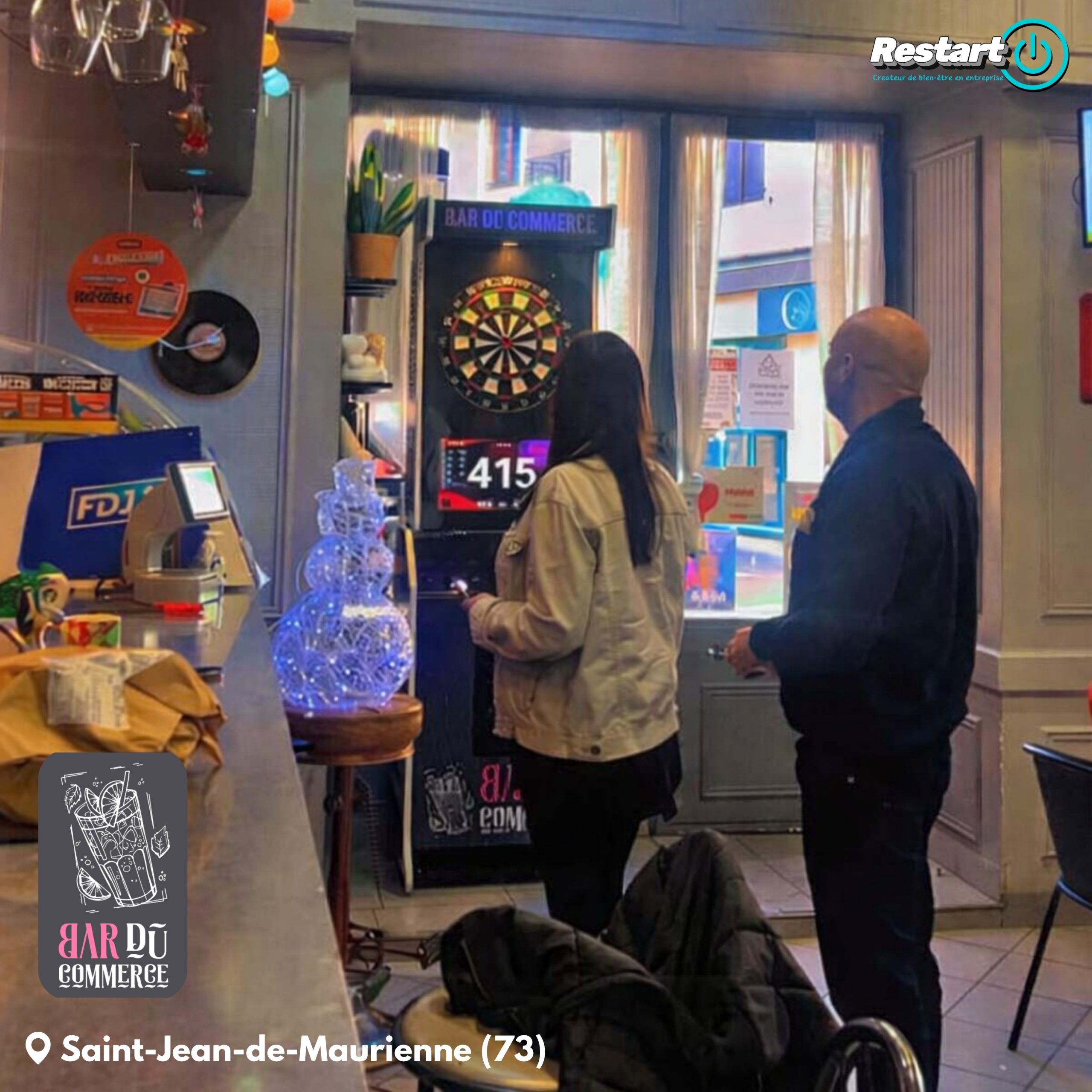 Clients jouant sur une borne de fléchettes interactive dans un bar à Saint-Jean-de-Maurienne