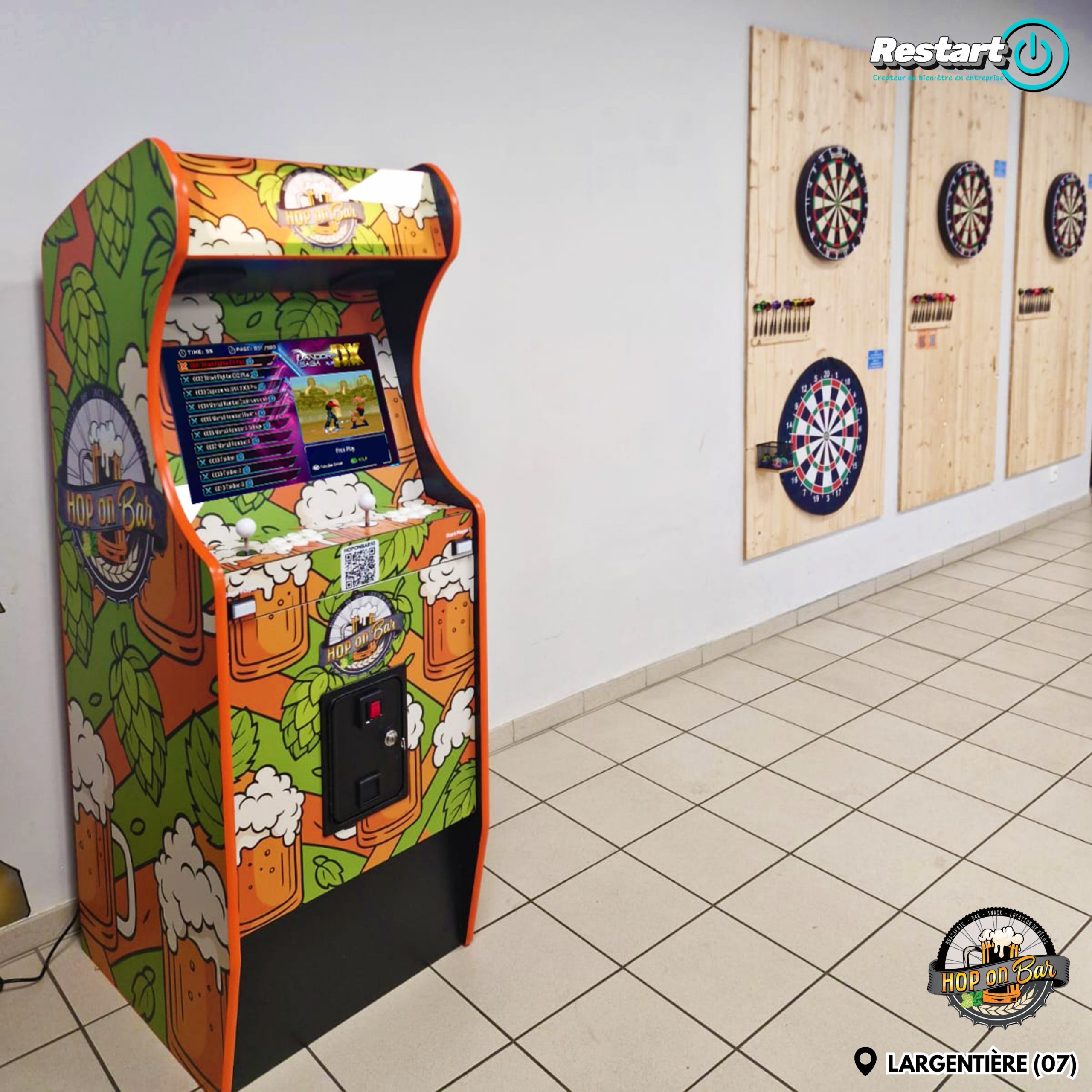 Borne d’arcade personnalisée Hop On Bar installée à Largentière, à côté d’un espace mural dédié aux fléchettes