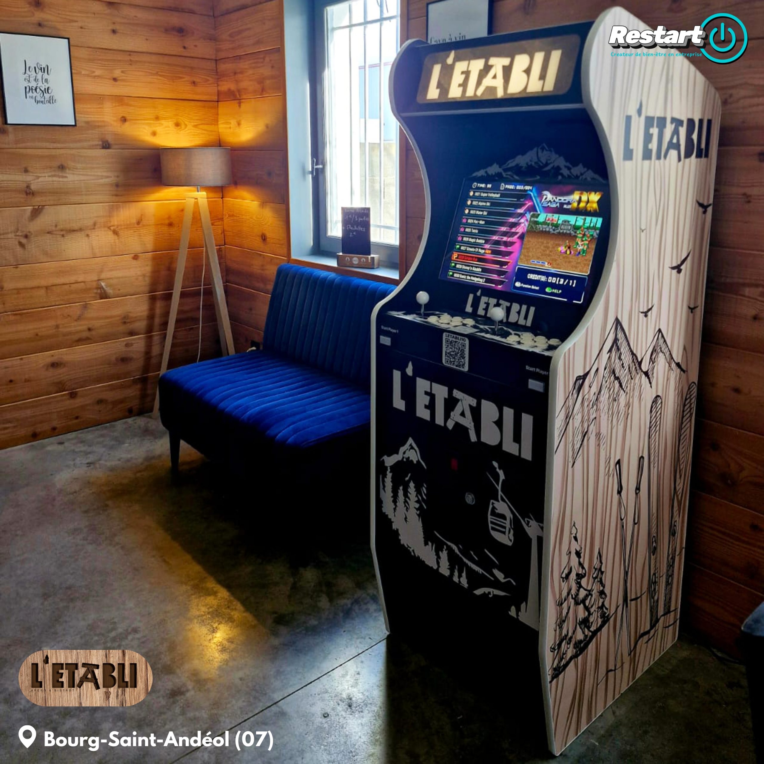 Vue rapprochée de la borne d'arcade noire et blanche installée au restaurant L’Établi à Bourg-Saint-Andéol