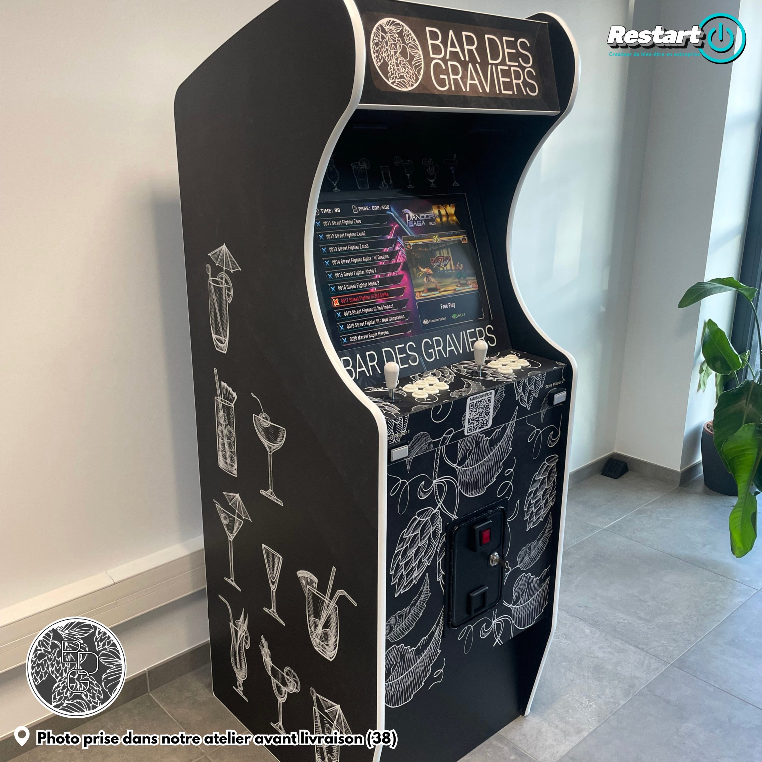 Vue de trois quarts d’une borne d’arcade noire et blanche personnalisée pour le Bar des Graviers, avant livraison