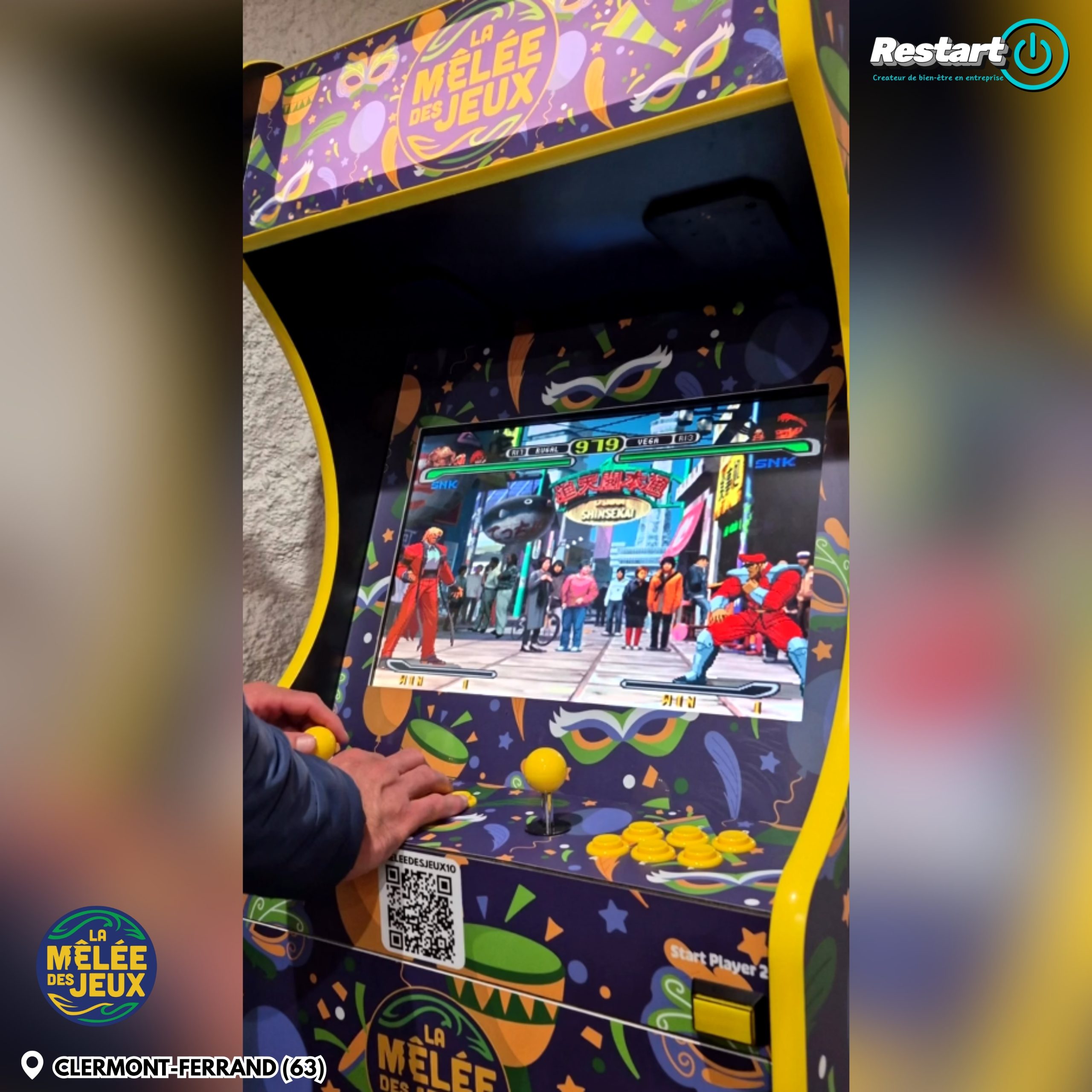 Gros plan sur une personne jouant à la borne d’arcade personnalisée La Mêlée des Jeux à Clermont-Ferrand
