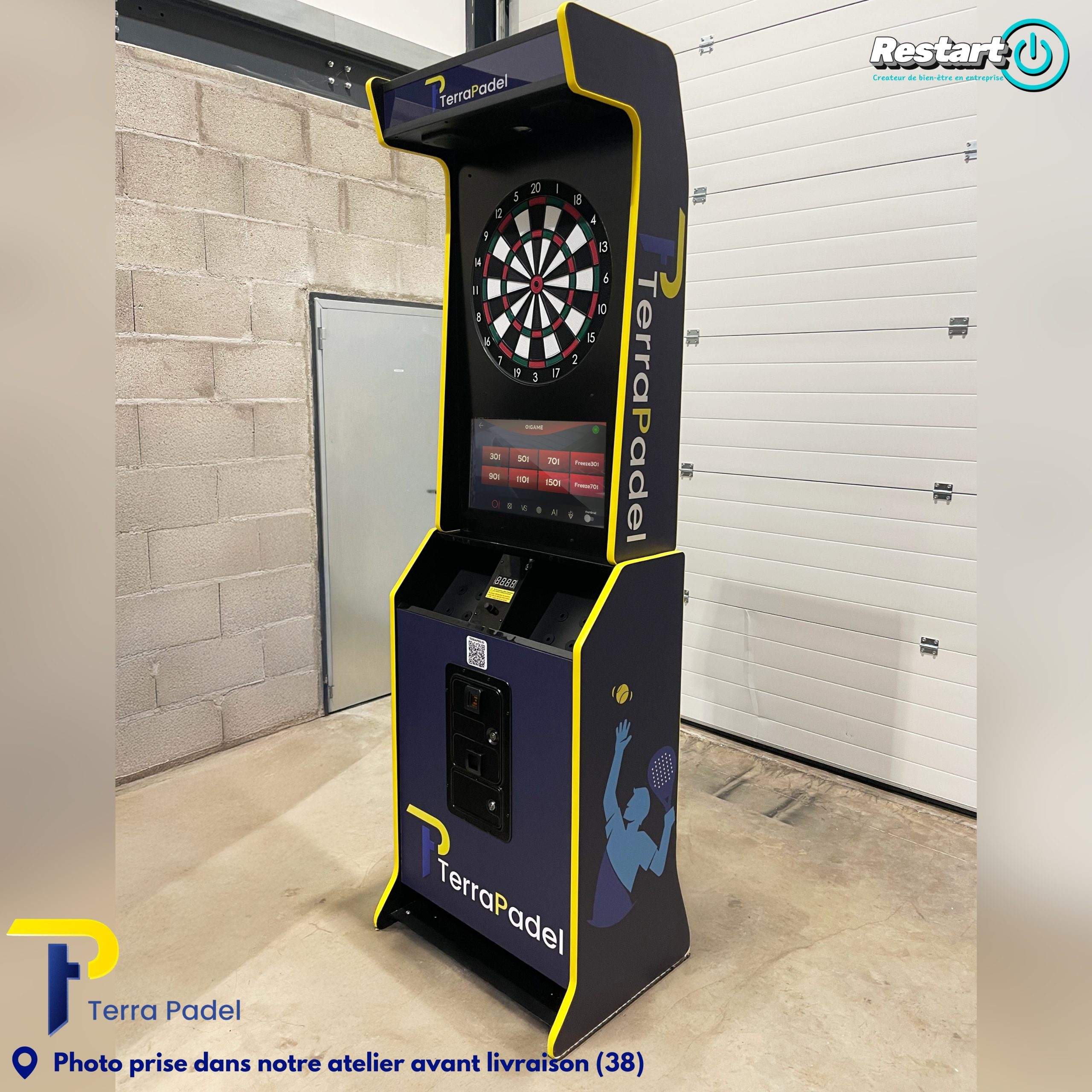 Borne de fléchettes interactive personnalisée bleu marine et jaune pour Terra Padel, photographiée dans l’atelier avant livraison