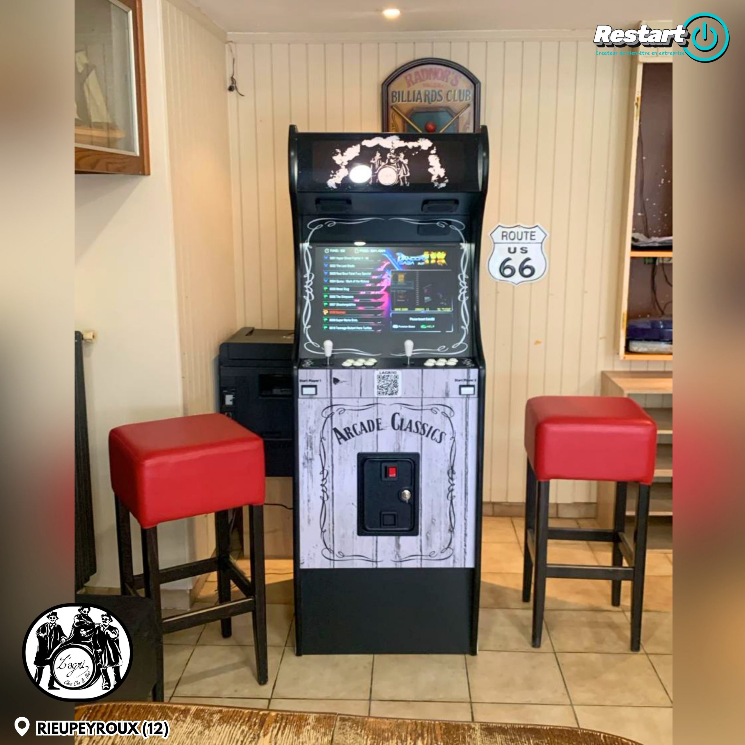 Borne d’arcade personnalisée installée au Café de l’Agriculture à Rieupeyroux, entre deux tabourets rouges