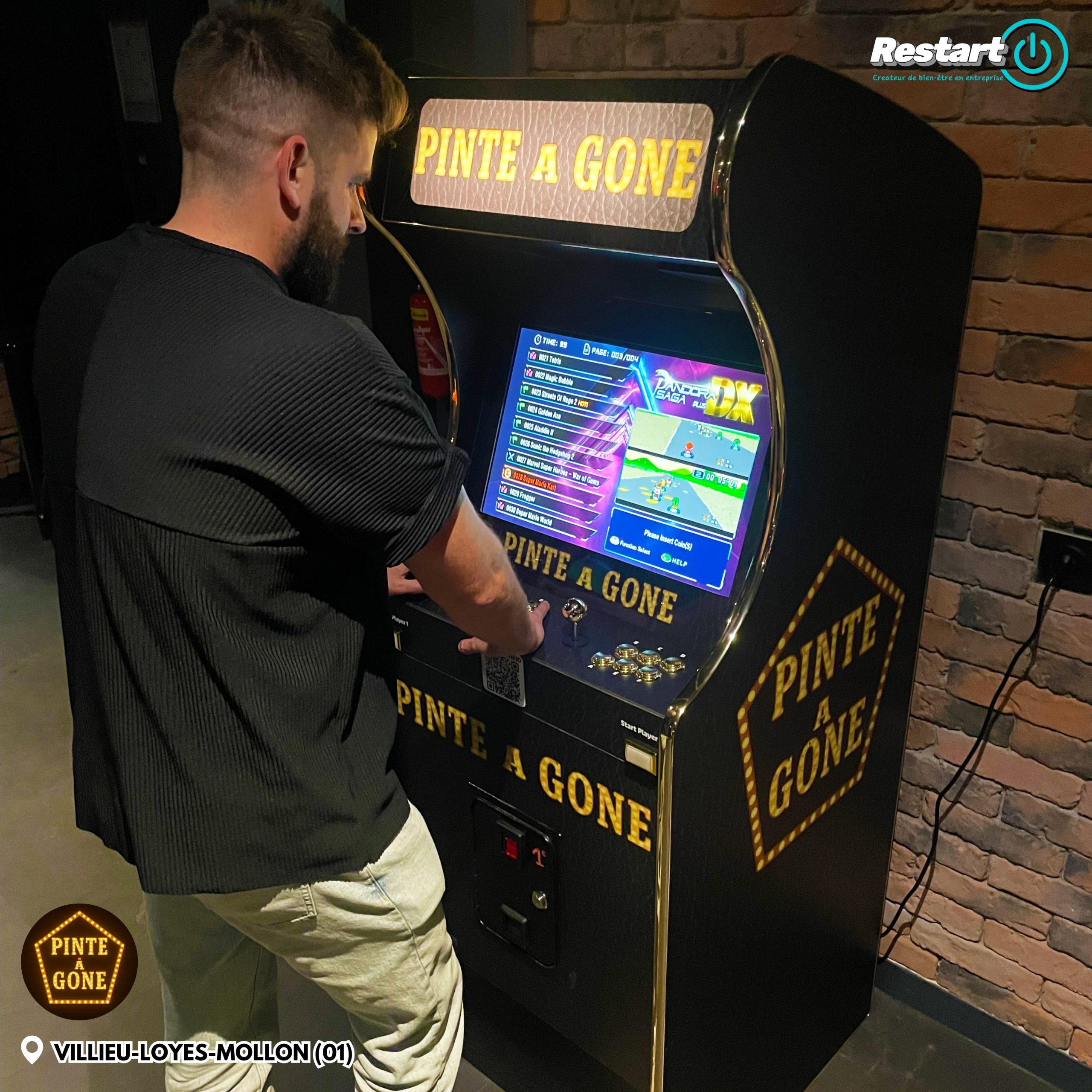 Client jouant sur une borne d’arcade noire et dorée dans un bar