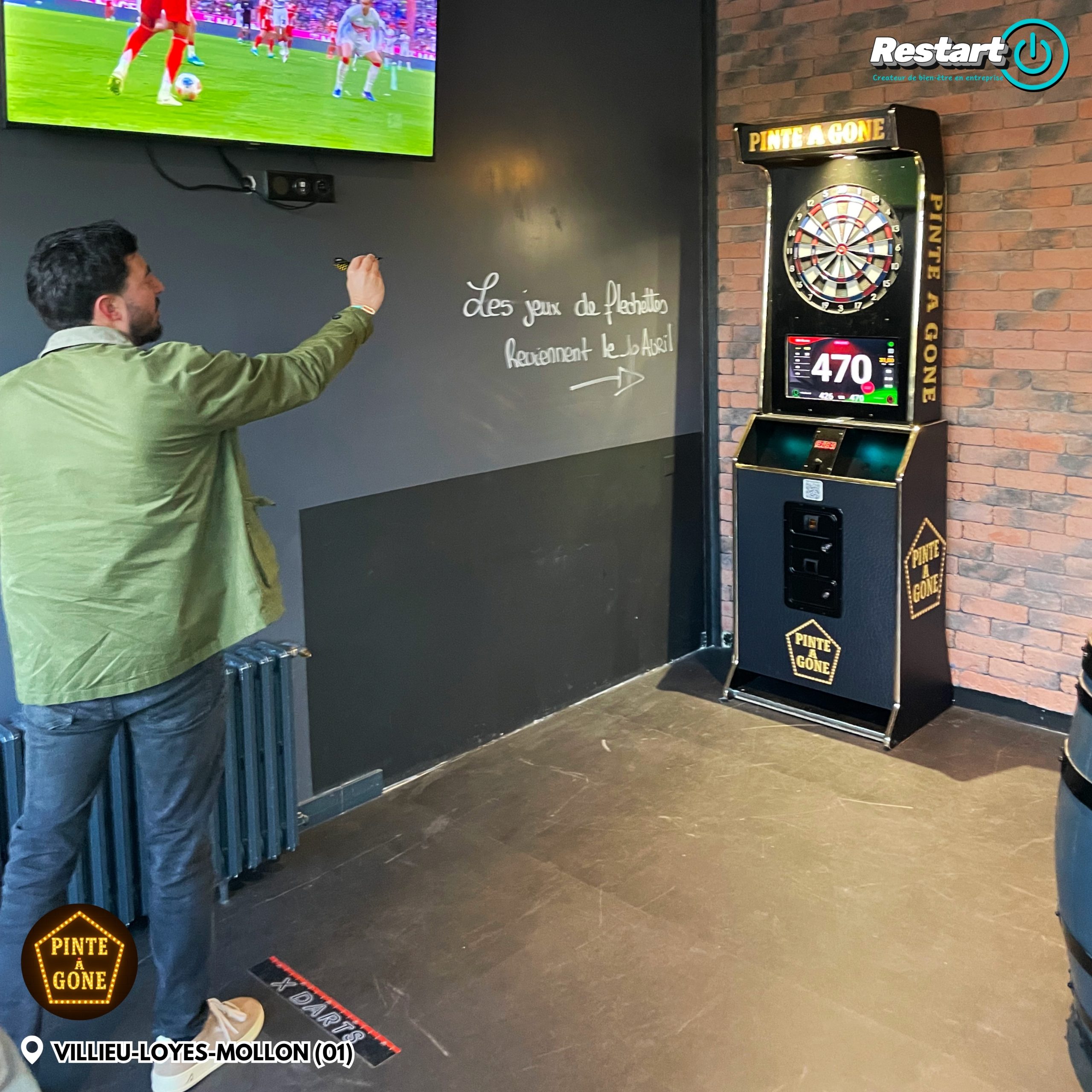 Client jouant sur une borne de fléchettes interactive dans un bar pendant un match de football